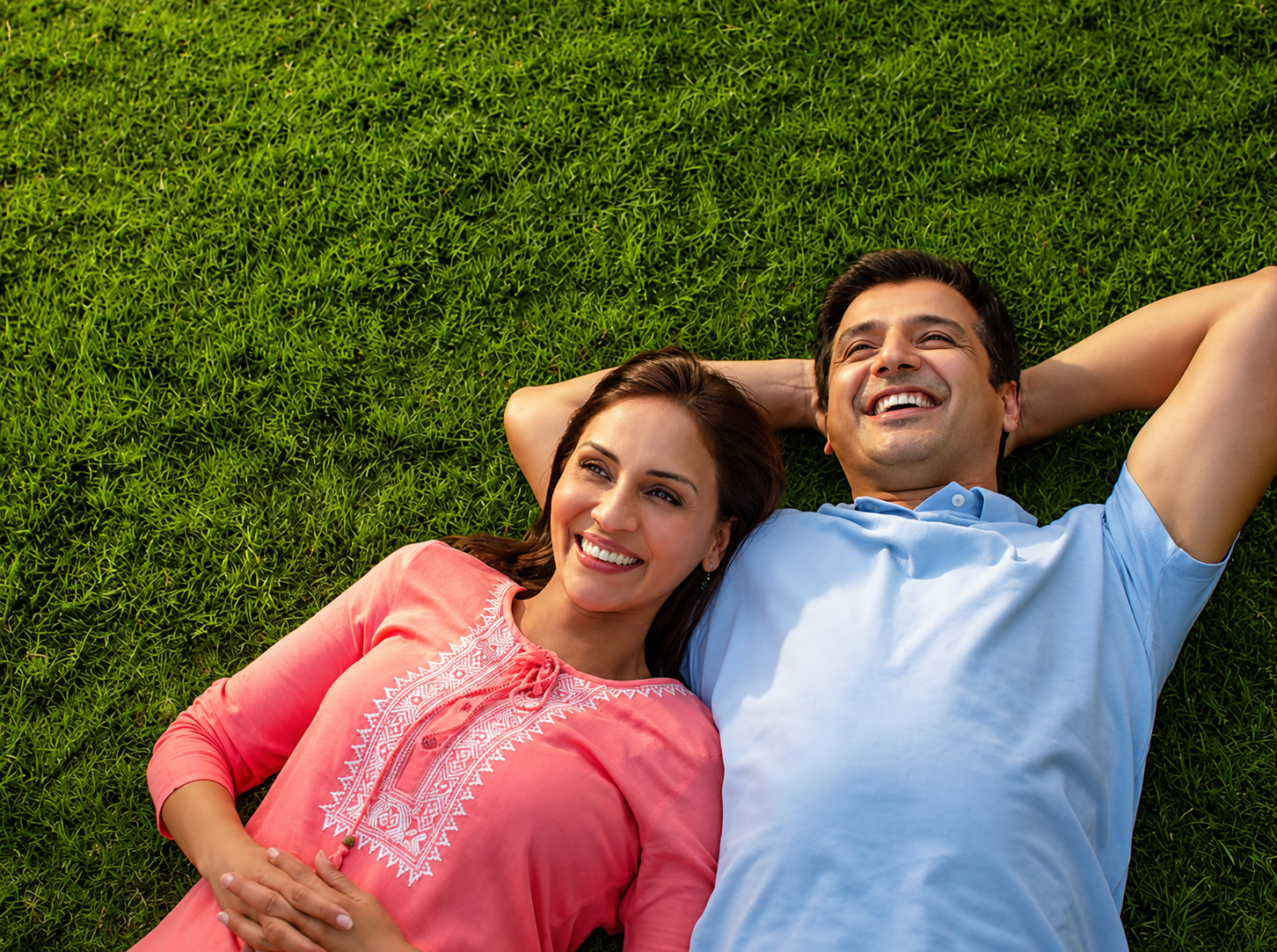 A couple relaxing together on green grass